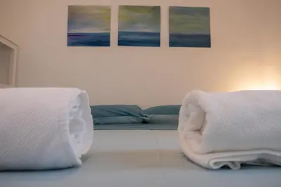a bedroom with two beds and two paintings on the wall at Isabel House in Isola delle Femmine