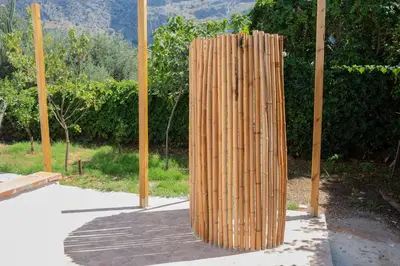 a wooden structure sitting on a sidewalk next to poles at Isabel House in Isola delle Femmine
