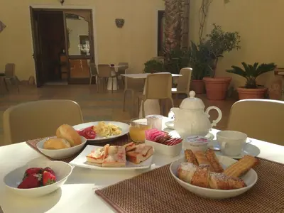 a table with plates of food and cups of coffee at Zingaro Hotel in San Vito lo Capo