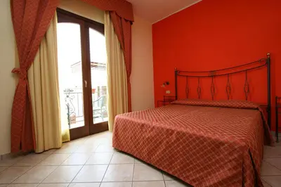 a bedroom with a bed and a large window at Zingaro Hotel in San Vito lo Capo