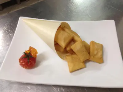 a white plate with a piece of food and a strawberry at Zingaro Hotel in San Vito lo Capo