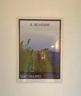a framed picture of a man walking on a beach at CasaMare Sant'Erasmo Sea View apartment & suites in Palermo