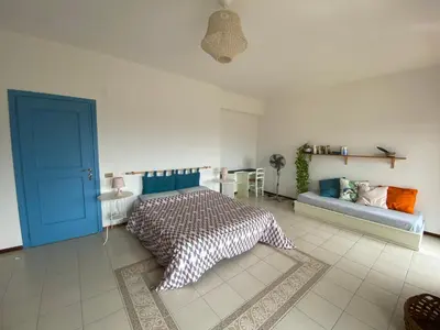 a bedroom with a bed with a blue door and a couch at CasaMare Sant'Erasmo Sea View apartment & suites in Palermo