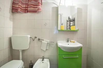a white bathroom with a toilet and a sink at Trip Rooms in Palermo