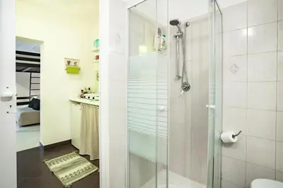 a bathroom with a glass shower with a toilet at Trip Rooms in Palermo