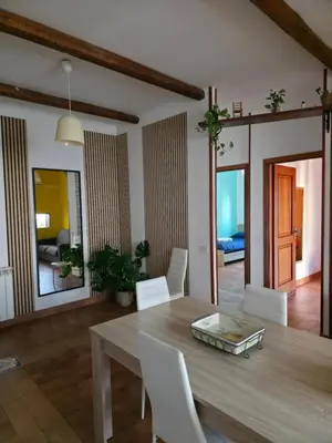 a dining room with a wooden table and white chairs at PTA Appartamento Girasole in Palermo