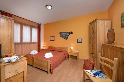a bedroom with a bed and a desk and a television at Hotel Halimeda in San Vito lo Capo