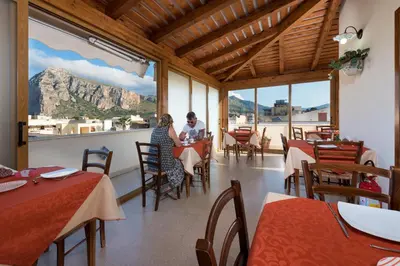 two people sitting at a table in a restaurant at Hotel Halimeda in San Vito lo Capo