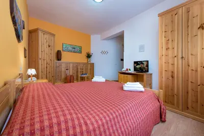 a bedroom with a large bed with a red blanket at Hotel Halimeda in San Vito lo Capo