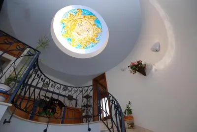 a spiral staircase with a painting on the ceiling at Hotel Halimeda in San Vito lo Capo