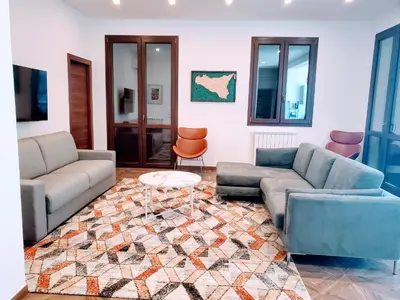 a living room with two couches and a table at Palazzo del Golfo in Castellammare del Golfo