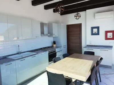 a kitchen with a wooden table and a kitchen with blue cabinets at Palazzo del Golfo in Castellammare del Golfo