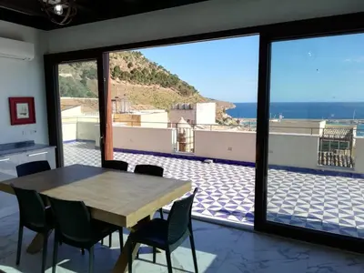 a dining room with a table and a view of the ocean at Palazzo del Golfo in Castellammare del Golfo