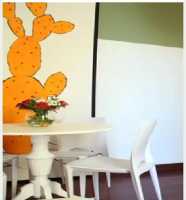 a table and two white chairs and a vase with flowers at Baru's House in Palermo