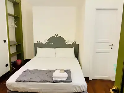 a bedroom with a bed with a green headboard at Baru's House in Palermo