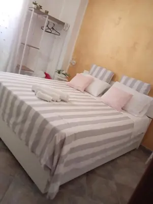 a large bed with pink and white sheets and pillows at Appartamento di Giò in Palermo
