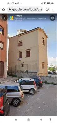a parking lot with cars parked in front of a building at Appartamento di Giò in Palermo