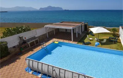 a large swimming pool with a view of the ocean at Villa Mucera in Ficarazzi