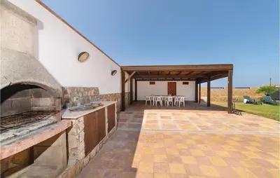 an outdoor kitchen and dining area with a pizza oven at Villa Mucera in Ficarazzi