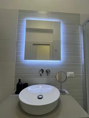 a bathroom with a white sink and a mirror at Calalula Apartment Palermo in Palermo