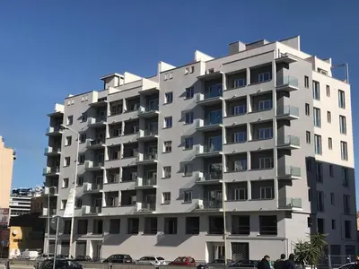 a tall building with cars parked in front of it at Calalula Apartment Palermo in Palermo