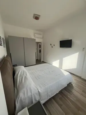 a bedroom with a bed and a flat screen tv at Calalula Apartment Palermo in Palermo
