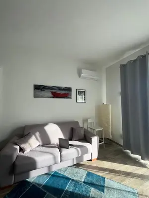 a living room with a gray couch and a blue rug at Calalula Apartment Palermo in Palermo