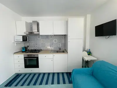 a kitchen with white cabinets and a stove top oven at La casa di fronte la spiaggia di San Vito lo capo in San Vito lo Capo