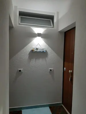 a room with a light on the wall at La casa di fronte la spiaggia di San Vito lo capo in San Vito lo Capo