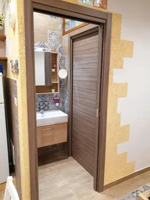a bathroom with a door leading to a sink at Il Sole della Guilla in Palermo