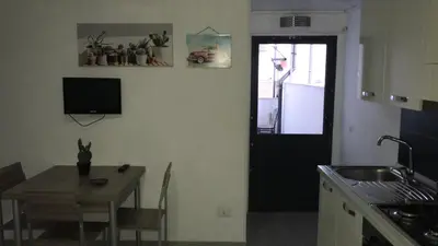 a kitchen with a table and a black door and a table and chairs at Casa Nicolina in Palermo