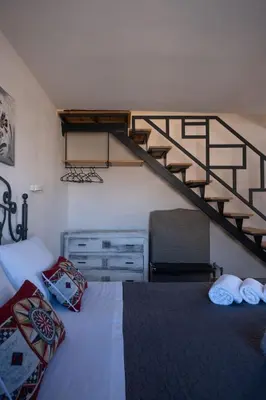 a bedroom with a bed and a spiral staircase at Sopra i tetti di Ballarò in Palermo