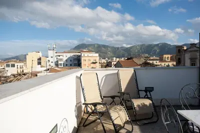 a balcony with chairs and a view of a city at Sopra i tetti di Ballarò in Palermo