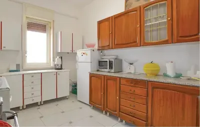 a kitchen with wooden cabinets and a white refrigerator at Charming Villa in Monreale with Private Pool in Pioppo