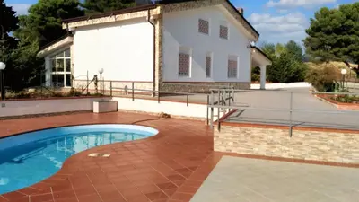 a house with a swimming pool in front of a building at Charming Villa in Monreale with Private Pool in Pioppo