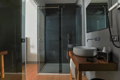 a bathroom with a sink and a glass shower at Palco Noir! in Palermo
