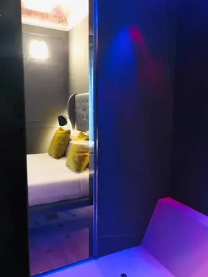 a mirror in a room with a bed with yellow pillows at Palco Noir! in Palermo