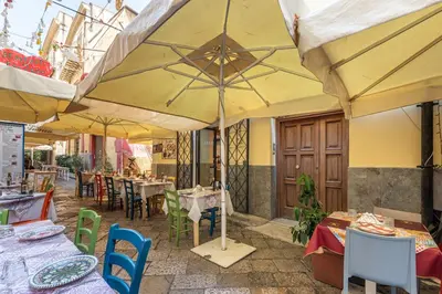 a patio with tables and chairs with umbrellas at Una Finestra sul Teatro Massimo by Wonderful Italy in Palermo