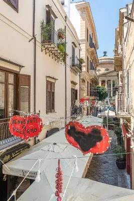 a table with red umbrellas on a street at Una Finestra sul Teatro Massimo by Wonderful Italy in Palermo