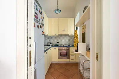 a kitchen with yellow cabinets and a white refrigerator at Una Finestra sul Teatro Massimo by Wonderful Italy in Palermo