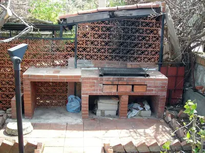 a brick fireplace with a grill in a backyard at Terrazza sul mare in Trabia