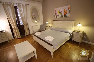 a bedroom with a bed and a table and a chair at Federico Secondo in Palermo