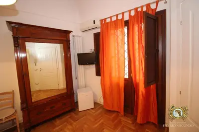 a room with an orange curtain and a mirror at Federico Secondo in Palermo