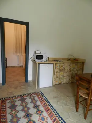 a room with a kitchen with a microwave on a counter at Masseria Acque Di Palermo in Roccapalumba