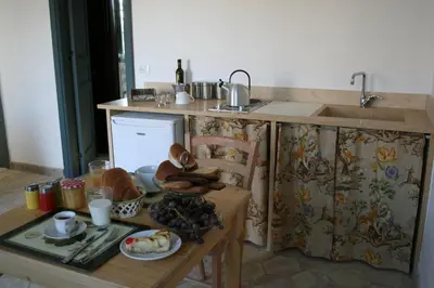 a kitchen with a sink and a table with food at Masseria Acque Di Palermo in Roccapalumba