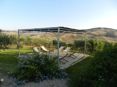 a group of chairs under a canopy in a garden at Masseria Acque Di Palermo in Roccapalumba