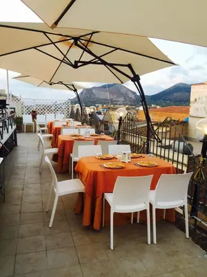 a restaurant with tables and chairs and an umbrella at Hotel Centrale Bagheria in Bagheria