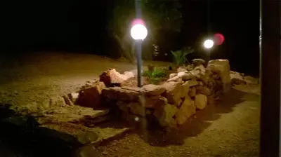 a street light next to a stone wall at night at Il Volo Dei Gabbiani in Scopello