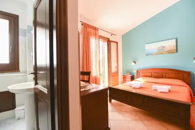 a bedroom with a bed and a bathroom with a sink at Aurora Castelluzzo in Castelluzzo