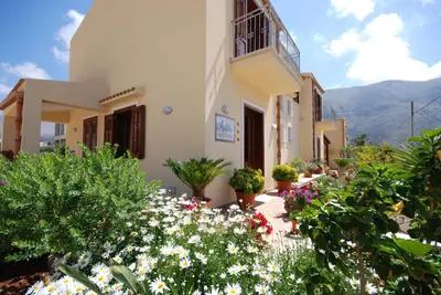 a building with flowers and plants in front of it at Aurora Castelluzzo in Castelluzzo
